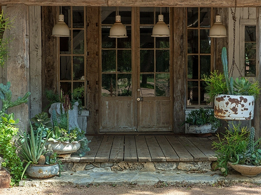 Rustic wooden porch with vintage doors, artisan planters, and lush whimsical succulents
