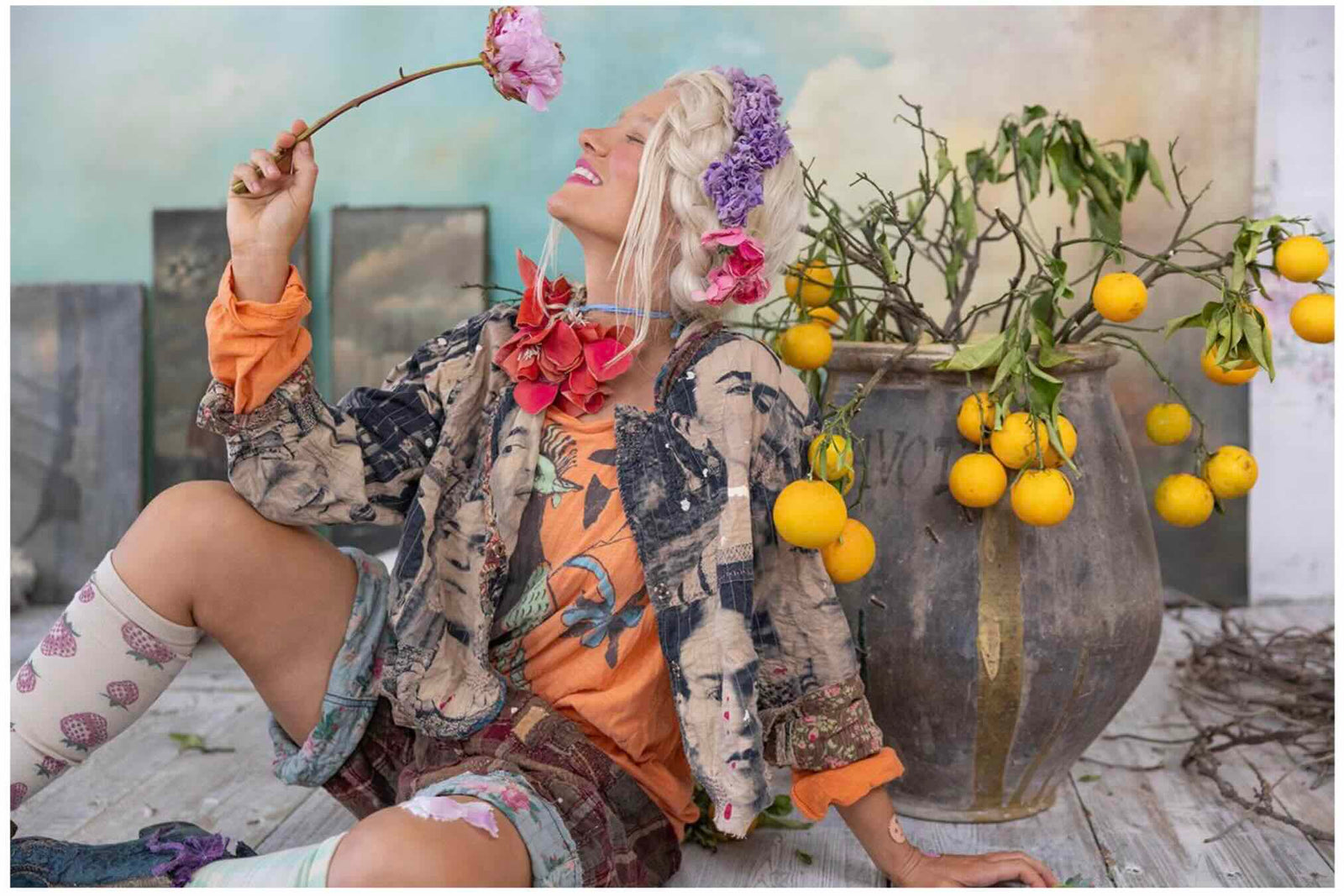 Woman in Magnolia Pearl artisan clothing with whimsical floral and vintage design, beside lemons