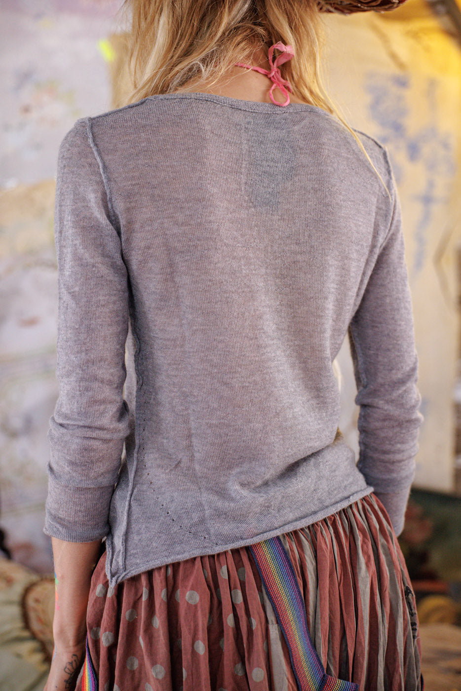 Woman in Magnolia Pearl artisan gray cashmere sweater and vintage polka dot skirt, whimsical style