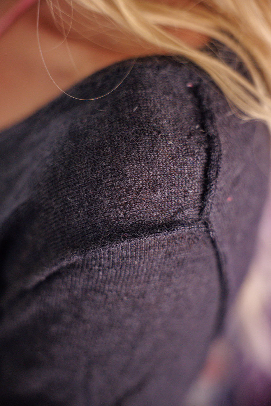 Close-up of Magnolia Pearl artisan charcoal cashmere sweater shoulder, vintage knit texture