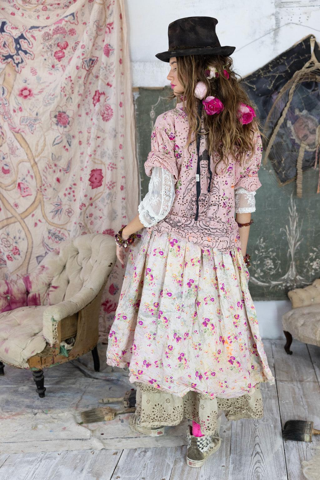 Woman in Magnolia Pearl artisan floral dress and vintage hat, whimsical boho style setting