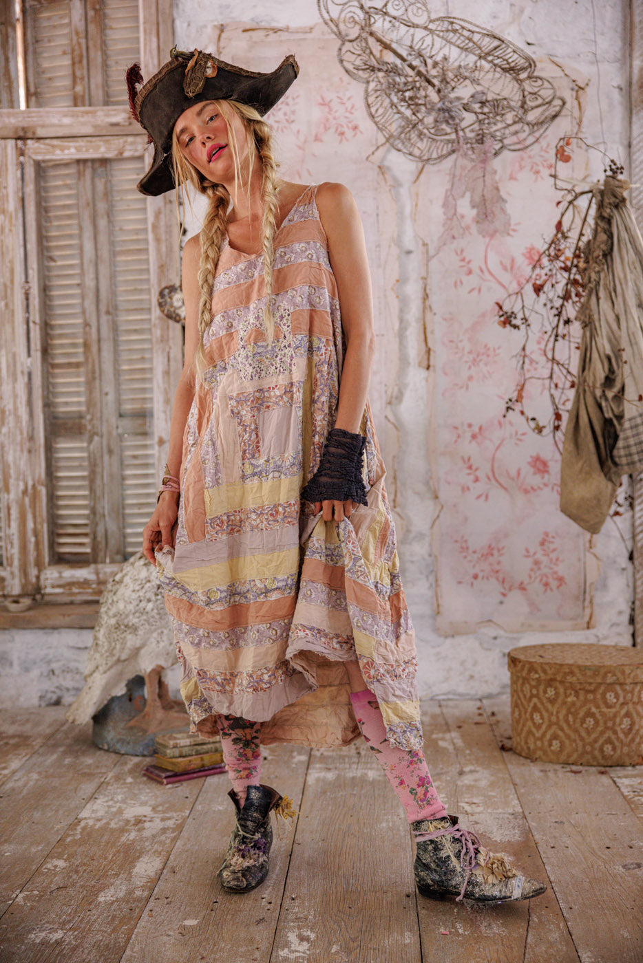Woman in Magnolia Pearl artisan patchwork dress and vintage pirate hat, boho whimsical style