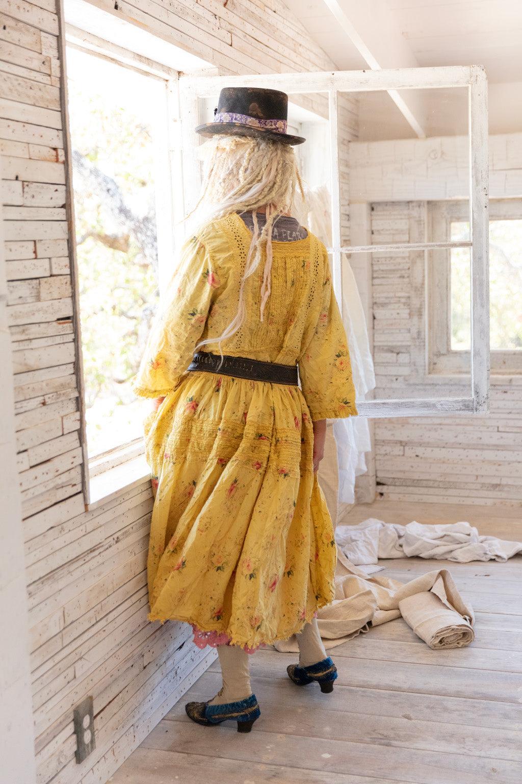 Woman in Magnolia Pearl yellow vintage artisan dress, top hat, whimsical eclectic style