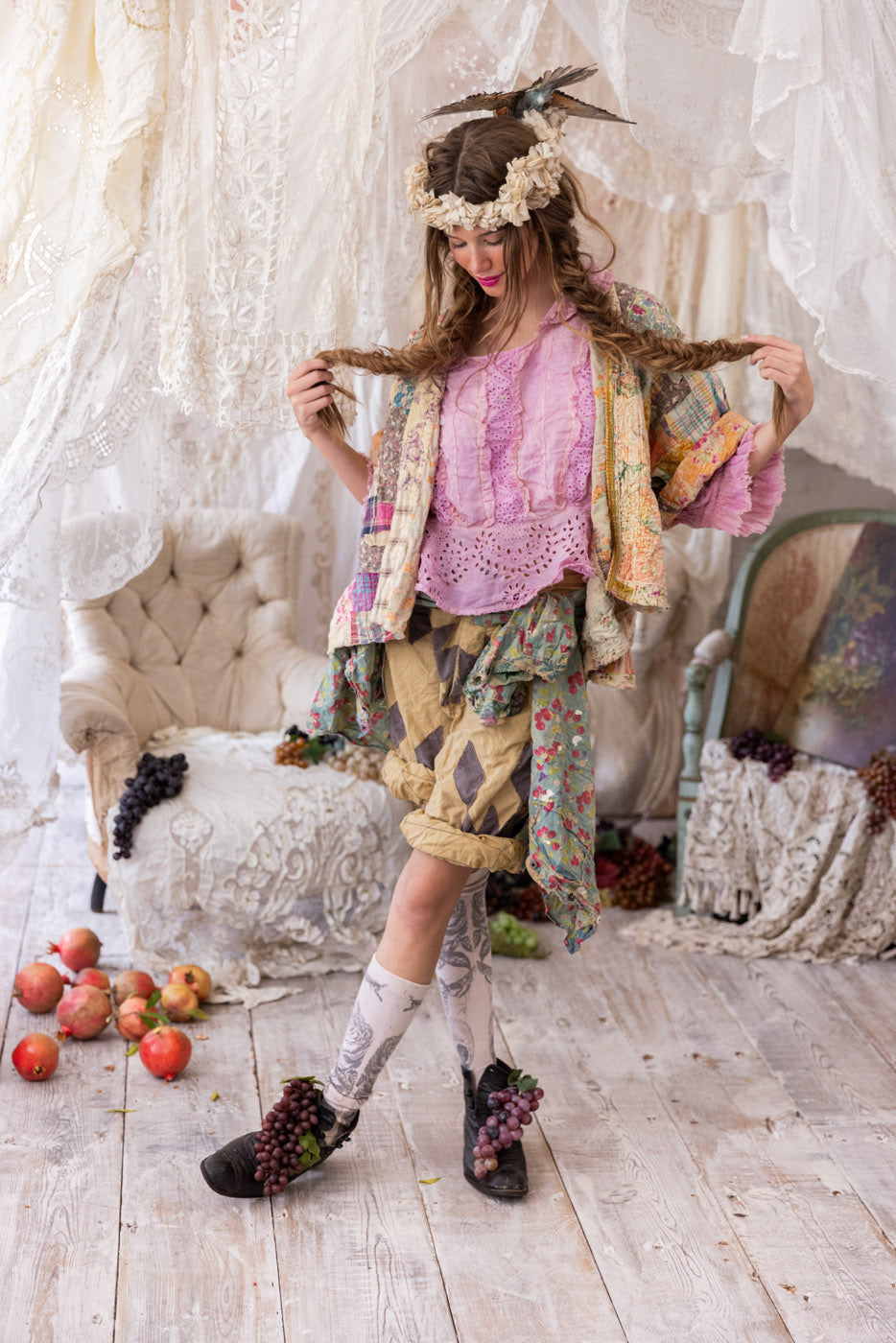 Woman in Magnolia Pearl artisan clothing with whimsical vintage style, floral crown, lace and fruit décor