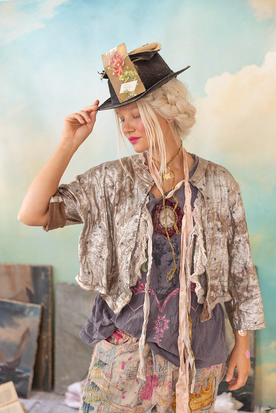 Woman in eclectic boho fashion, floral card on black hat, pastel background, vintage style