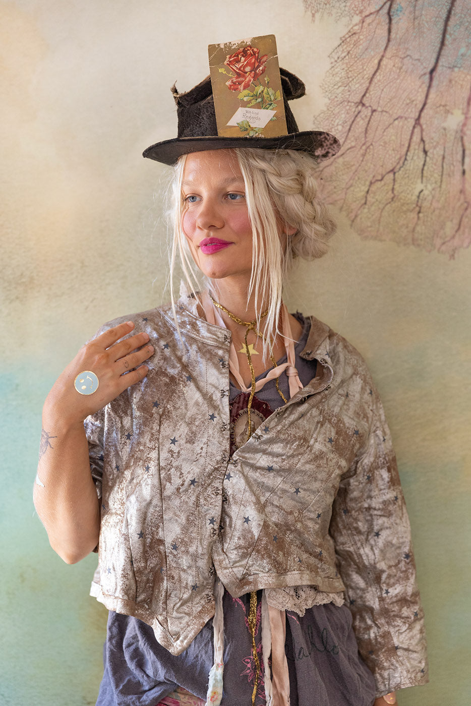 Woman in eclectic boho fashion, floral card on black hat, pastel background, vintage style