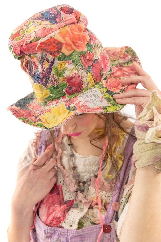 Woman in Magnolia Pearl artisan vintage floral hat with whimsical bird design and colorful clothing