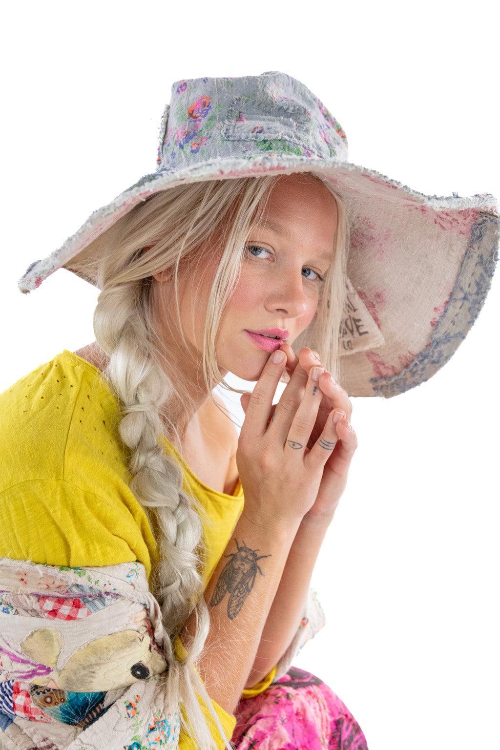 Magnolia Pearl artisan vintage floral bucket hat, whimsical design, worn by woman in yellow top