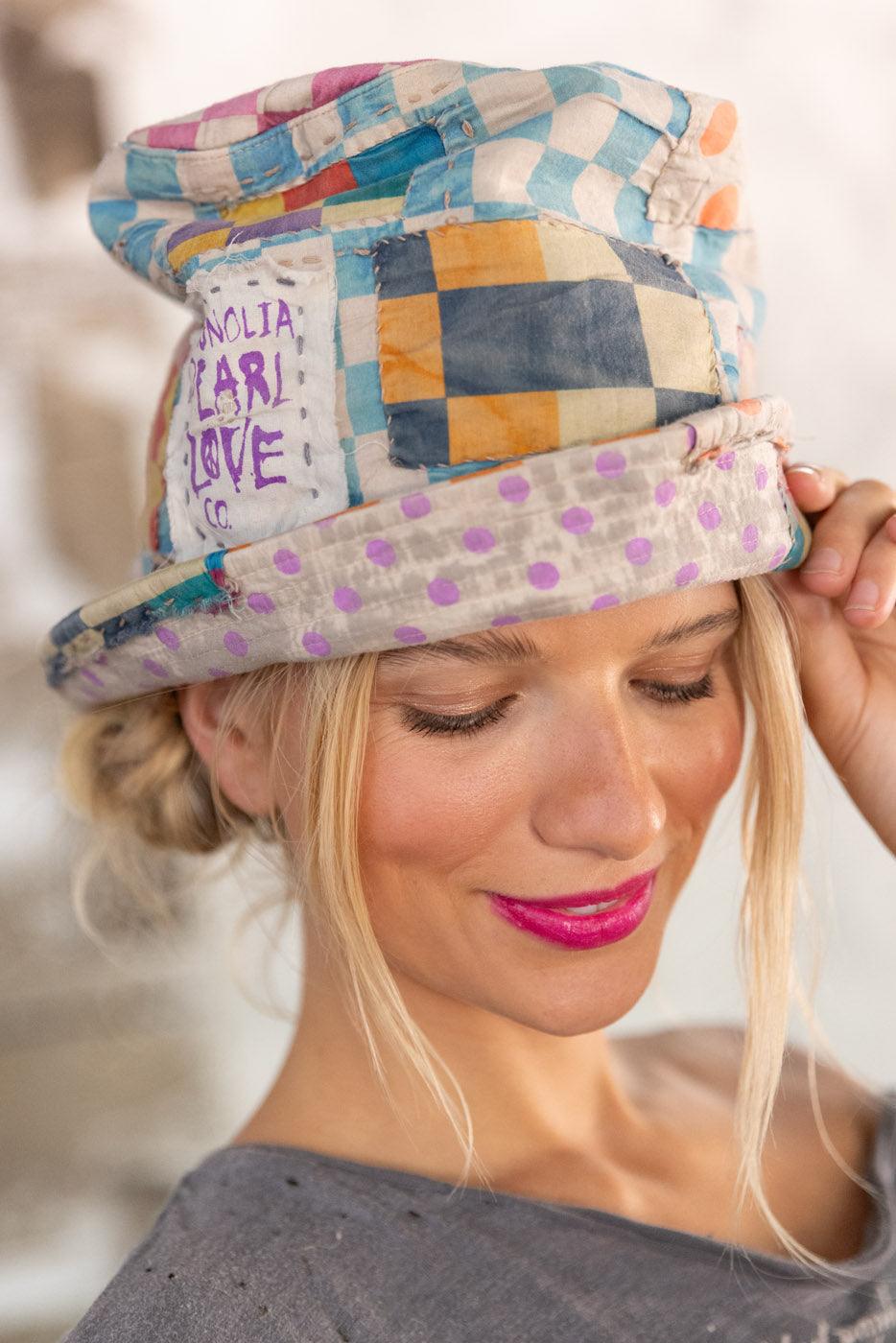 Smiling woman wearing Magnolia Pearl patchwork artisan hat with whimsical vintage style