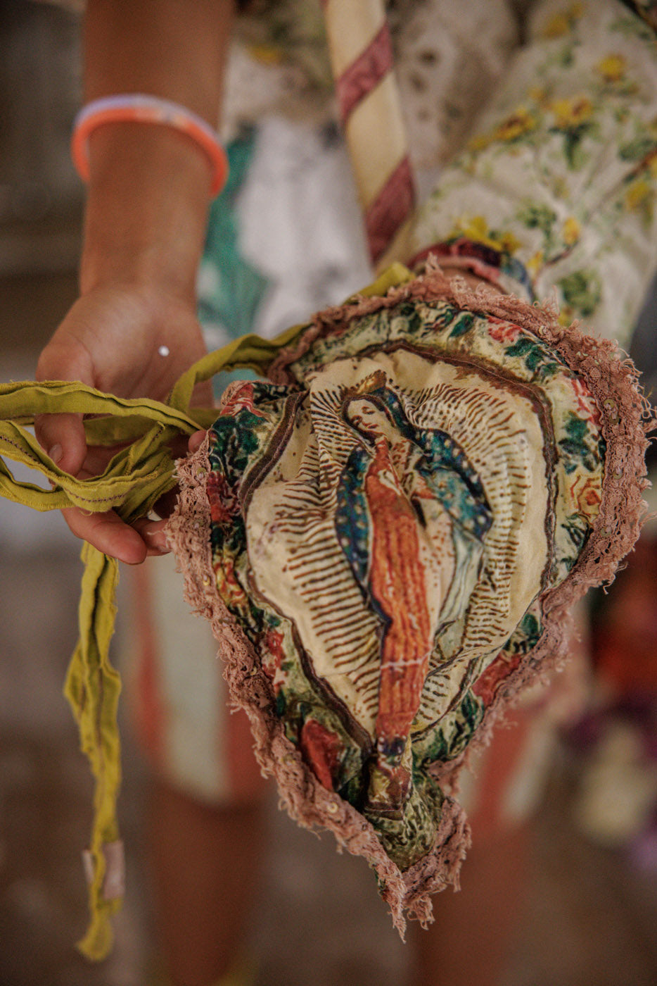 Woman in Magnolia Pearl artisan clothing with floral crown, vintage lace, and whimsical heart face paint