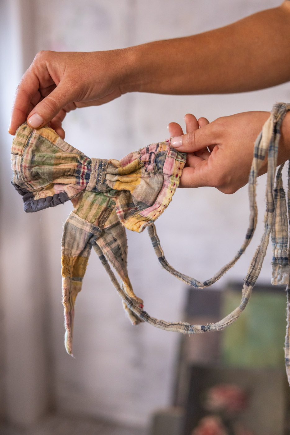 Woman in Magnolia Pearl artisan vintage hat, patchwork scarf, whimsical t-shirt and denim jacket