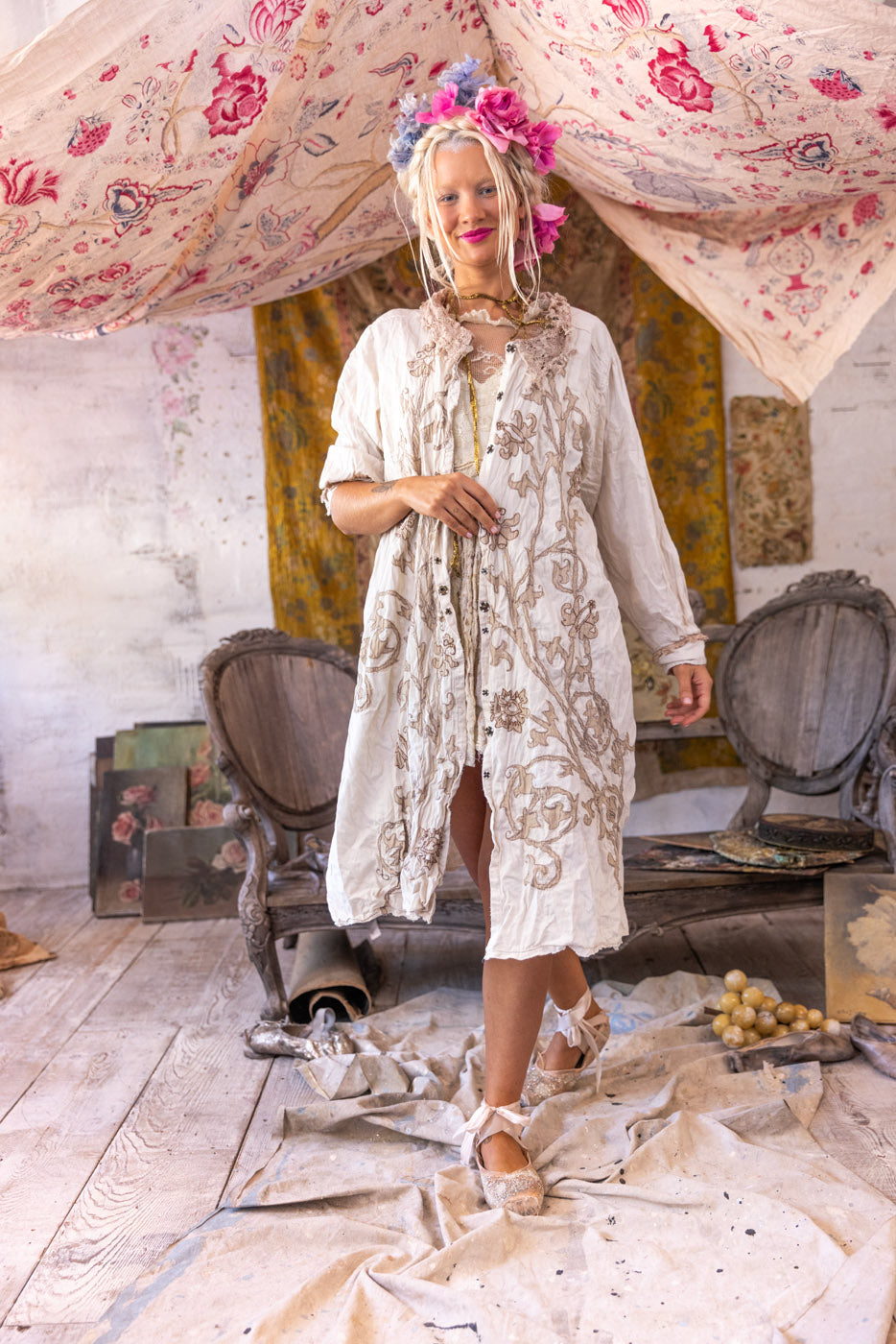 Woman in Magnolia Pearl artisan vintage embroidered jacket dress, floral crown, whimsical rustic setting