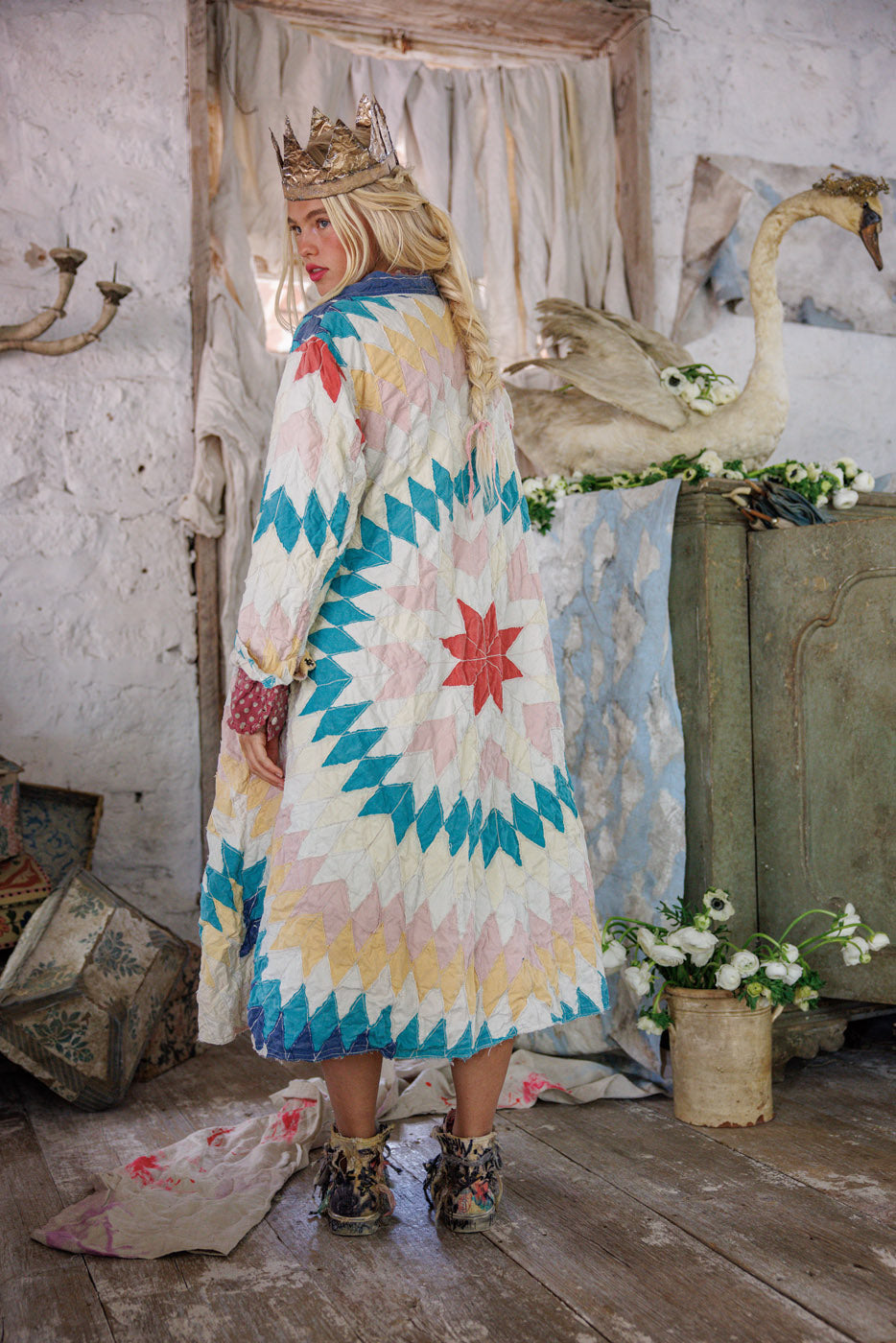 Woman in Magnolia Pearl artisan quilted coat with whimsical vintage design, rustic floral room