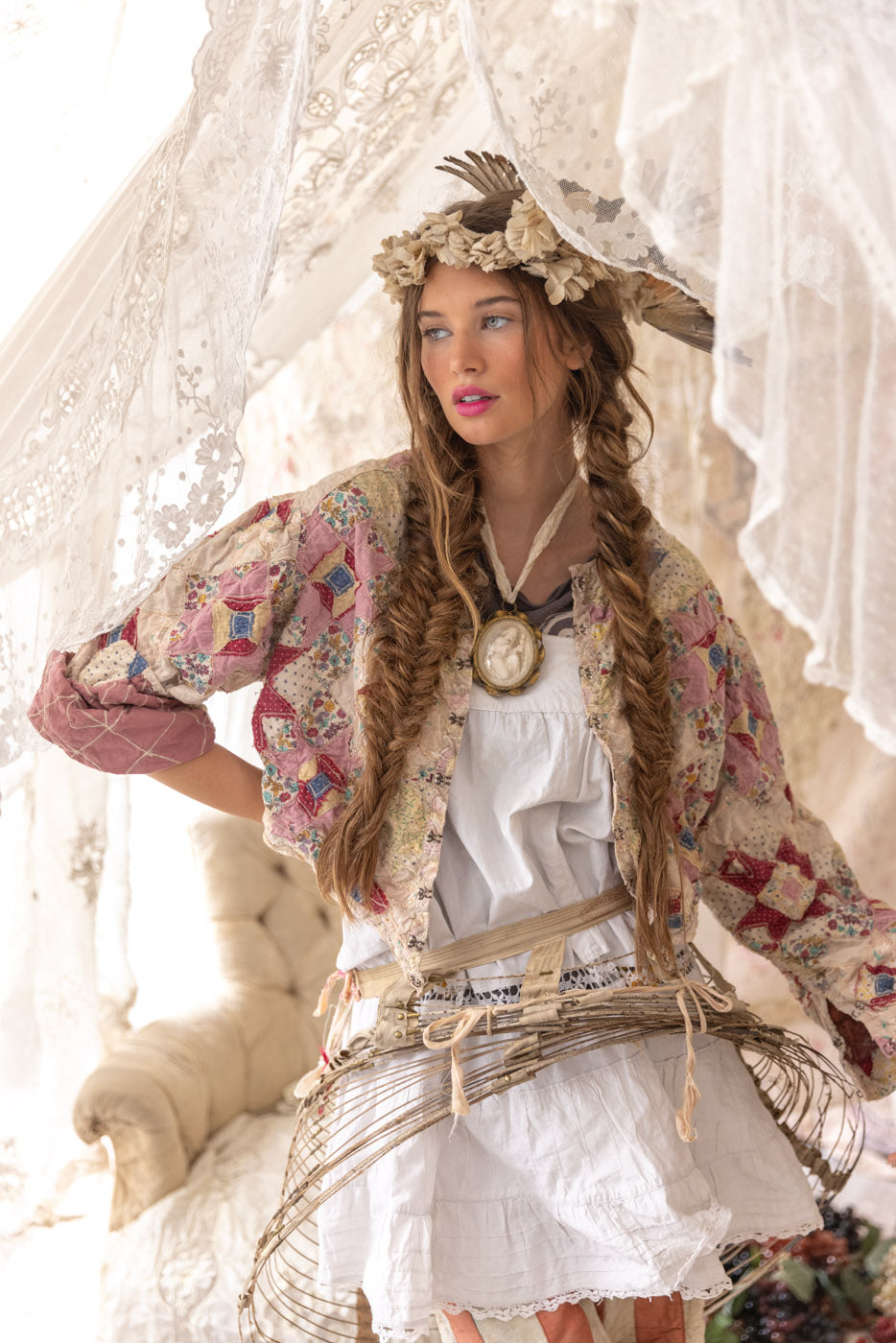 Woman in Magnolia Pearl artisan vintage patchwork clothing, whimsical floral crown, lace decor, rustic setting
