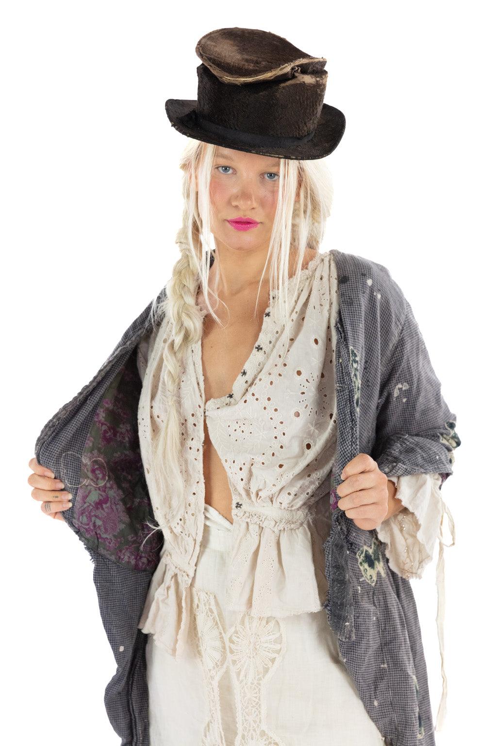 Woman in Magnolia Pearl artisan jacket and vintage lace blouse with whimsical hat