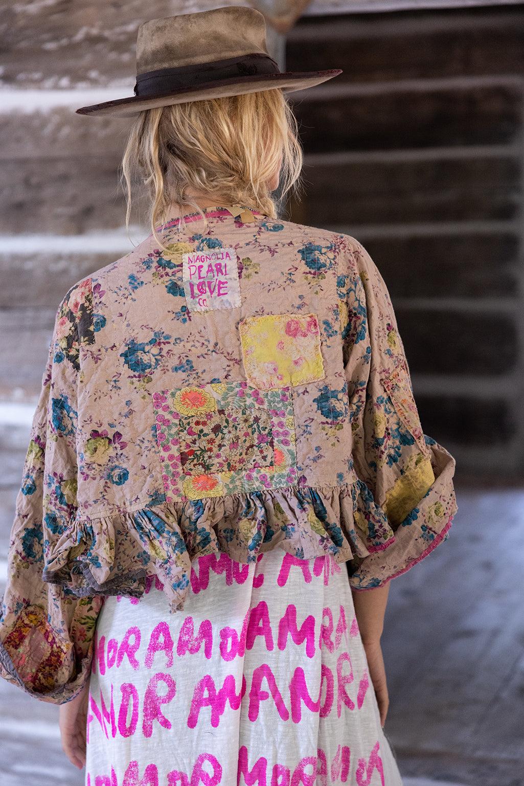 Woman in Magnolia Pearl floral patchwork artisan jacket and whimsical vintage dress