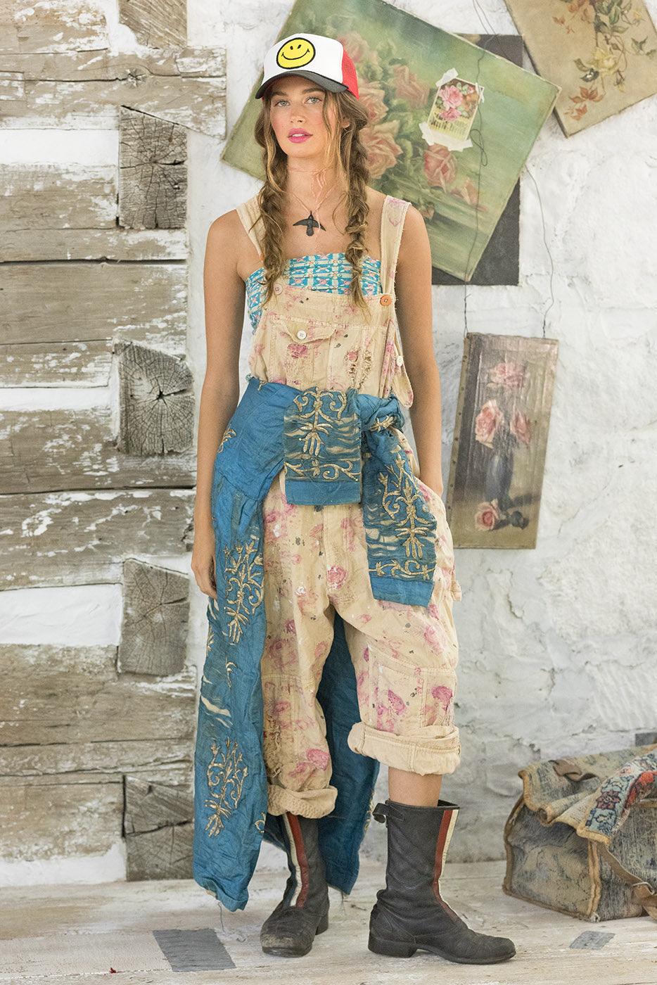 Woman in Magnolia Pearl vintage floral overalls, artisan whimsical design, standing indoors