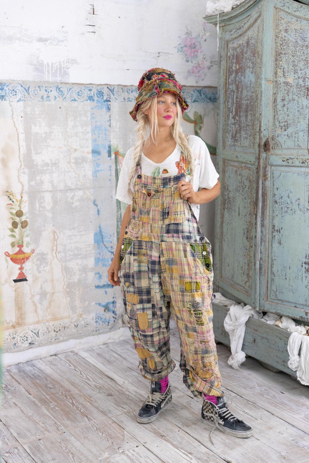 Woman in Magnolia Pearl patchwork overalls and floral hat, vintage whimsical artisan style