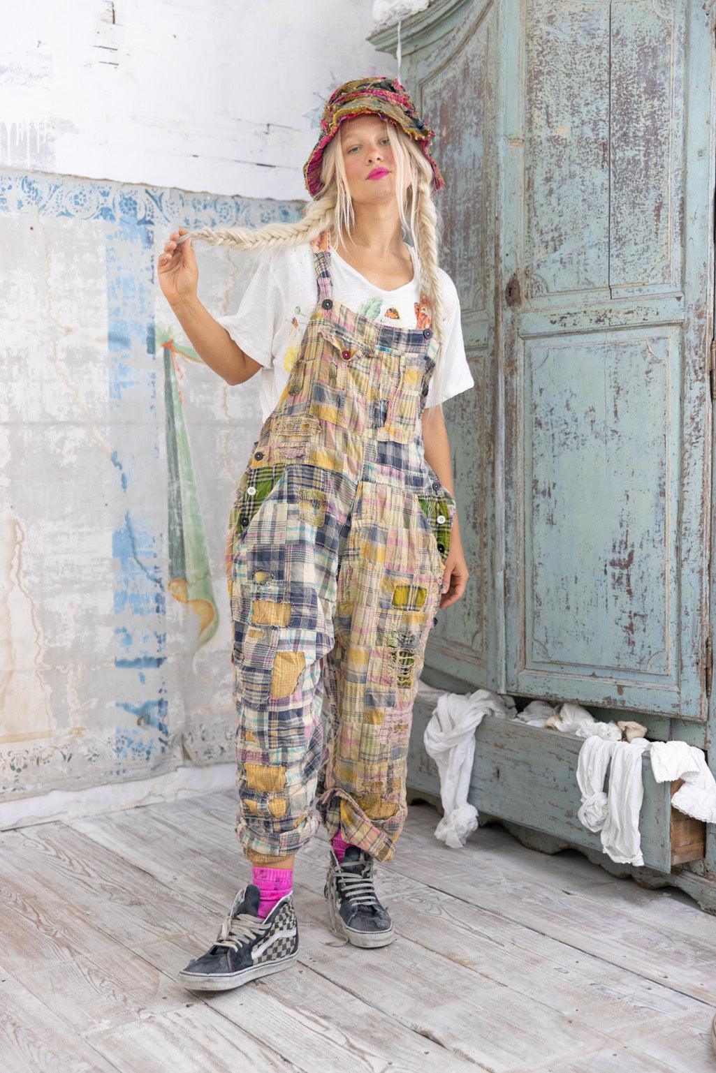 Woman in Magnolia Pearl patchwork overalls and floral hat, vintage whimsical artisan style