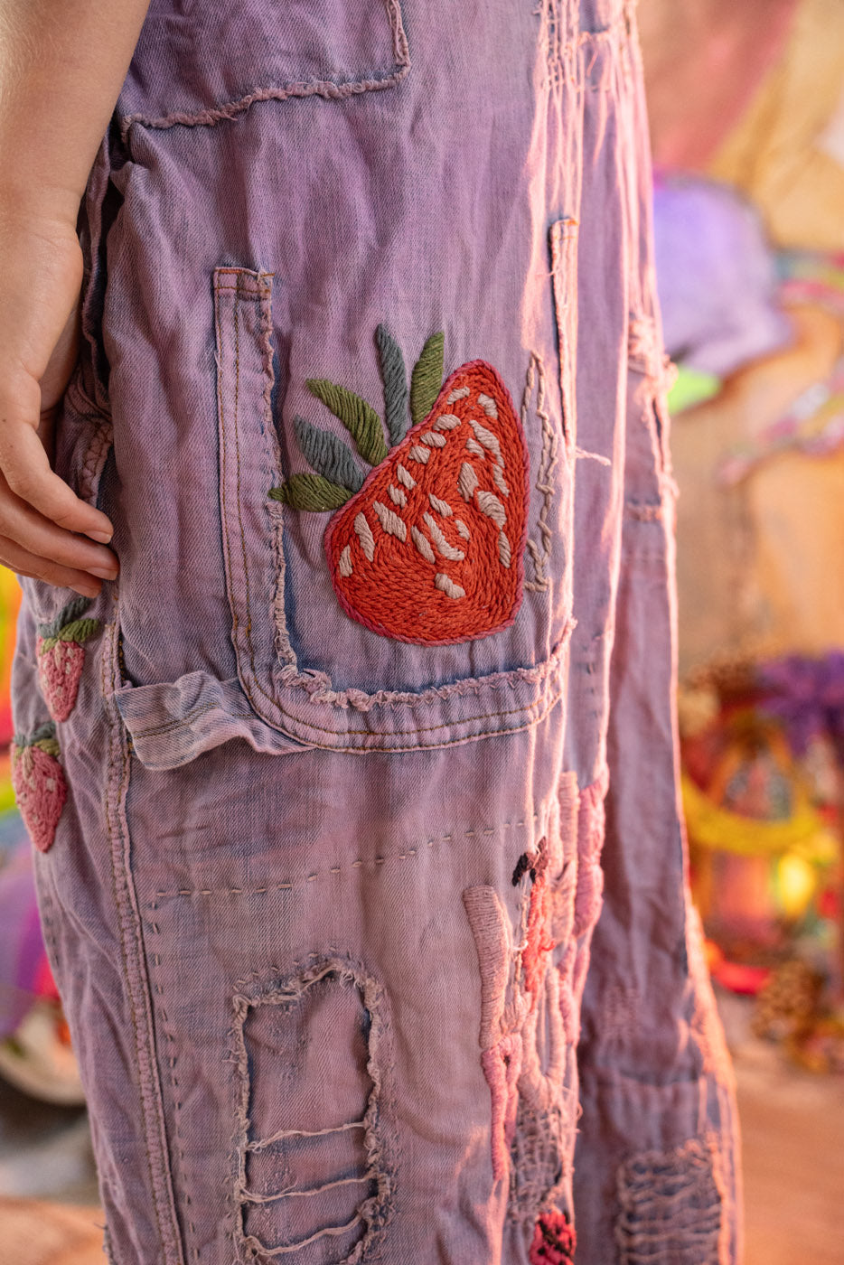 Purple denim vintage overalls with a strawberry patch on a colorful background