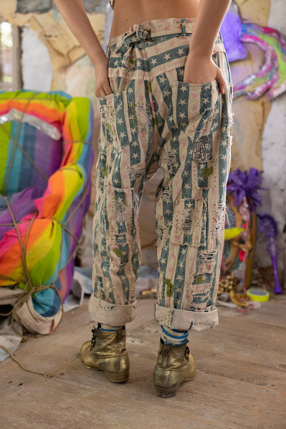 Person wearing star patterned pants with a colorful, abstract background