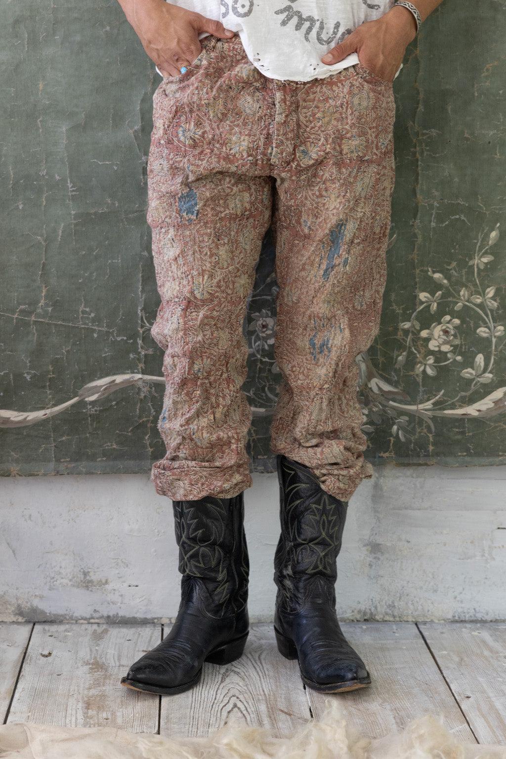 Model in Magnolia Pearl artisan vintage pants, whimsical t-shirt, and cowboy boots, rustic setting