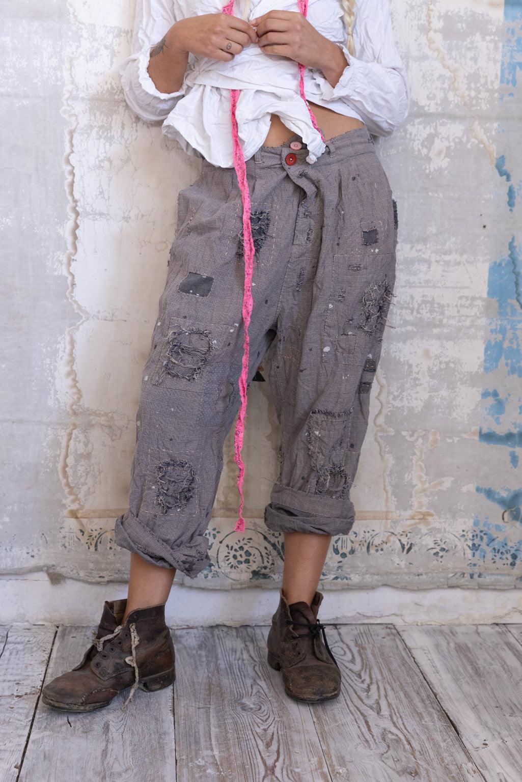 Woman in Magnolia Pearl artisan vintage patchwork pants, white blouse, bonnet, rustic setting