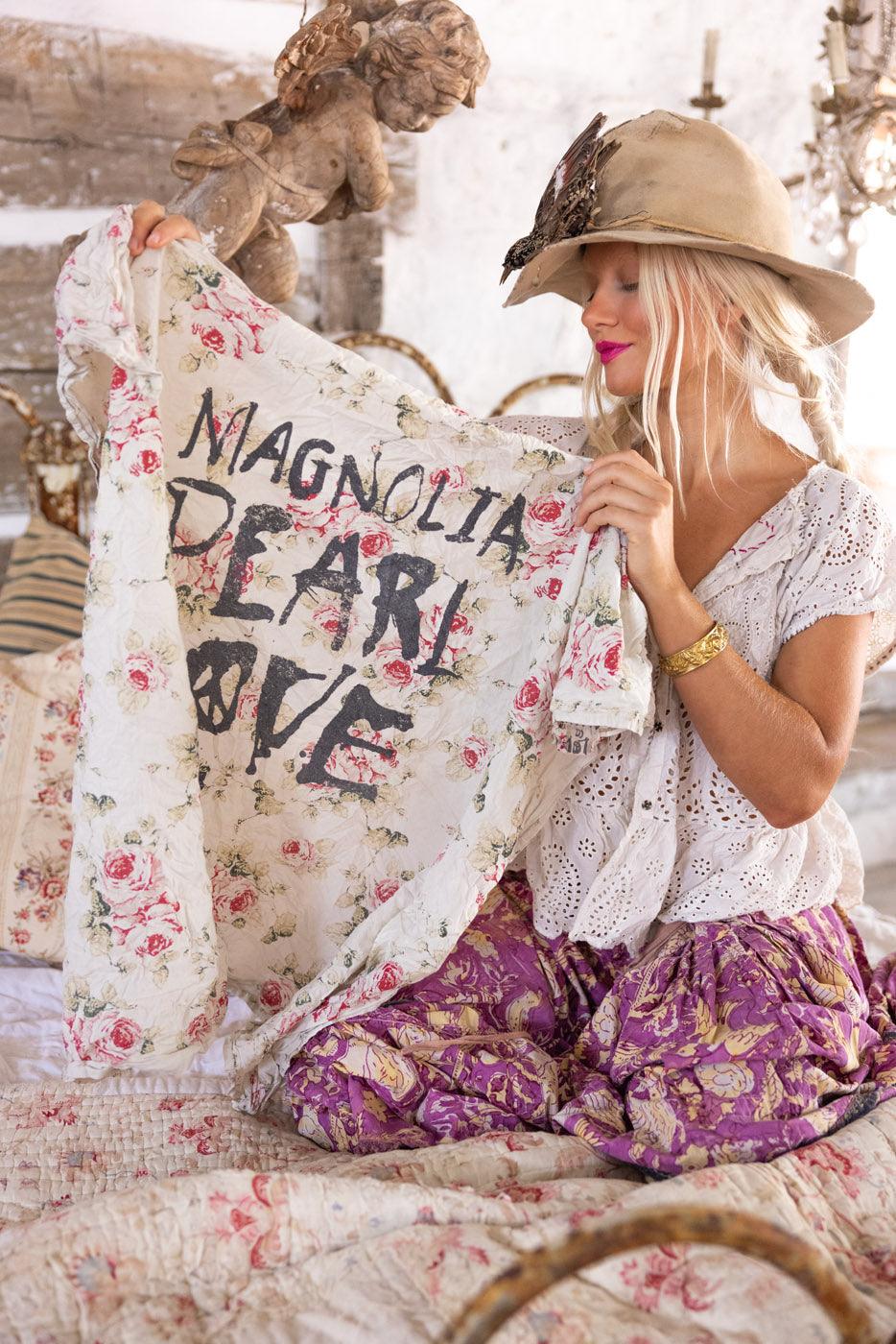 Woman in vintage Magnolia Pearl artisan clothing holding floral scarf with whimsical design