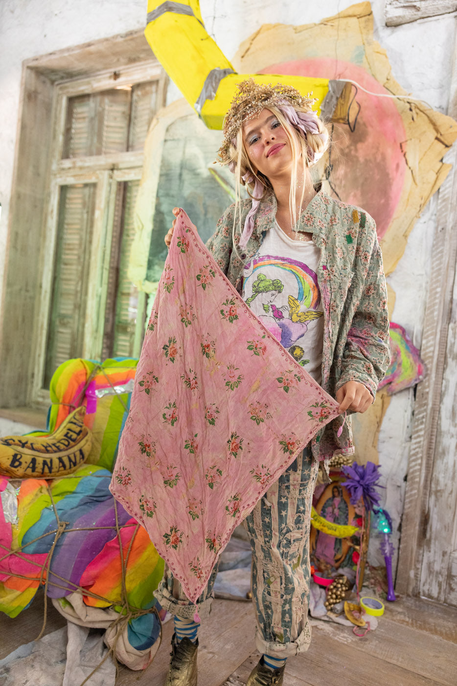 Person holding a pink floral scarf with colorful chairs and decorations in the background