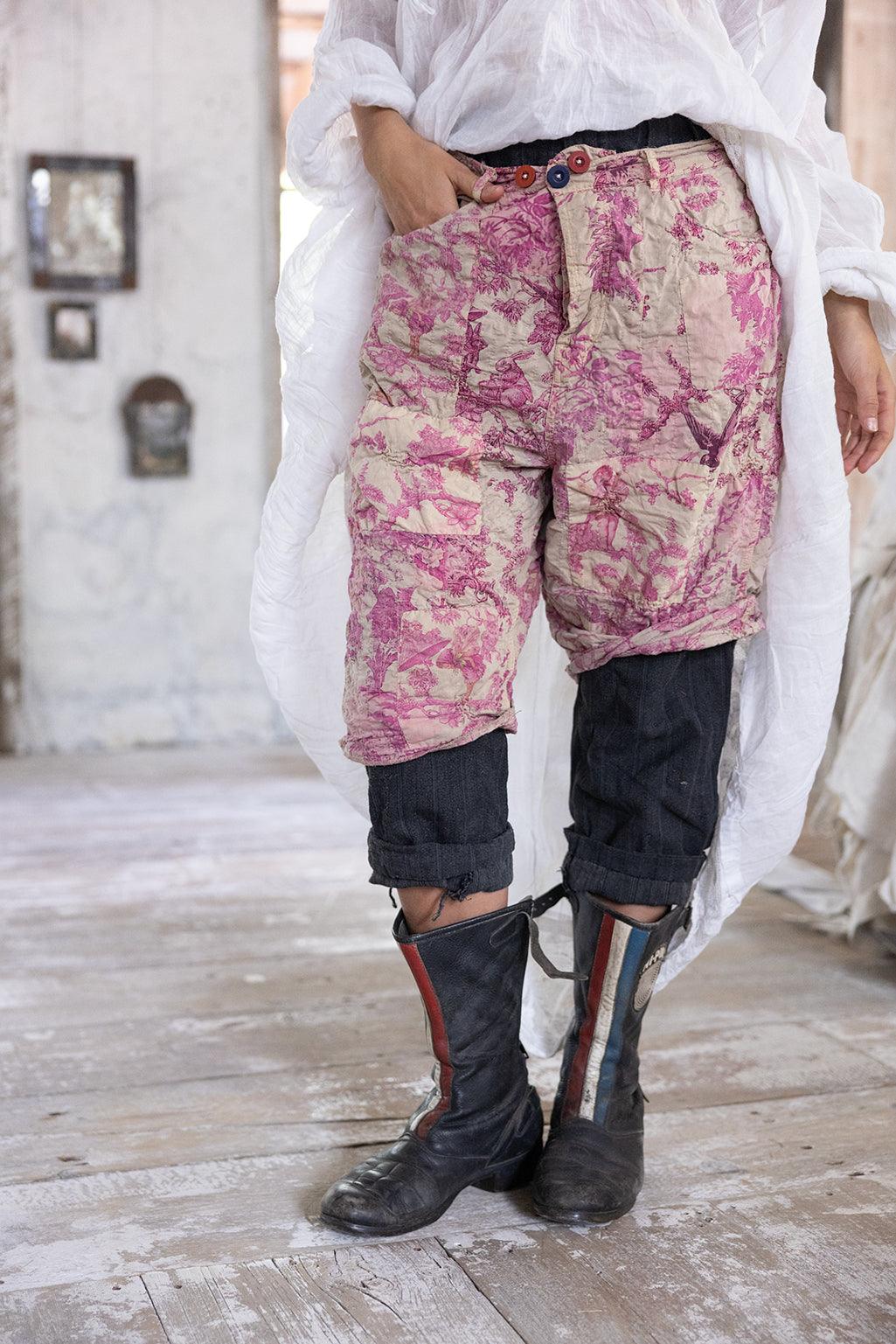 Woman in Magnolia Pearl artisan clothing, whimsical pink shorts, vintage boots, rustic room