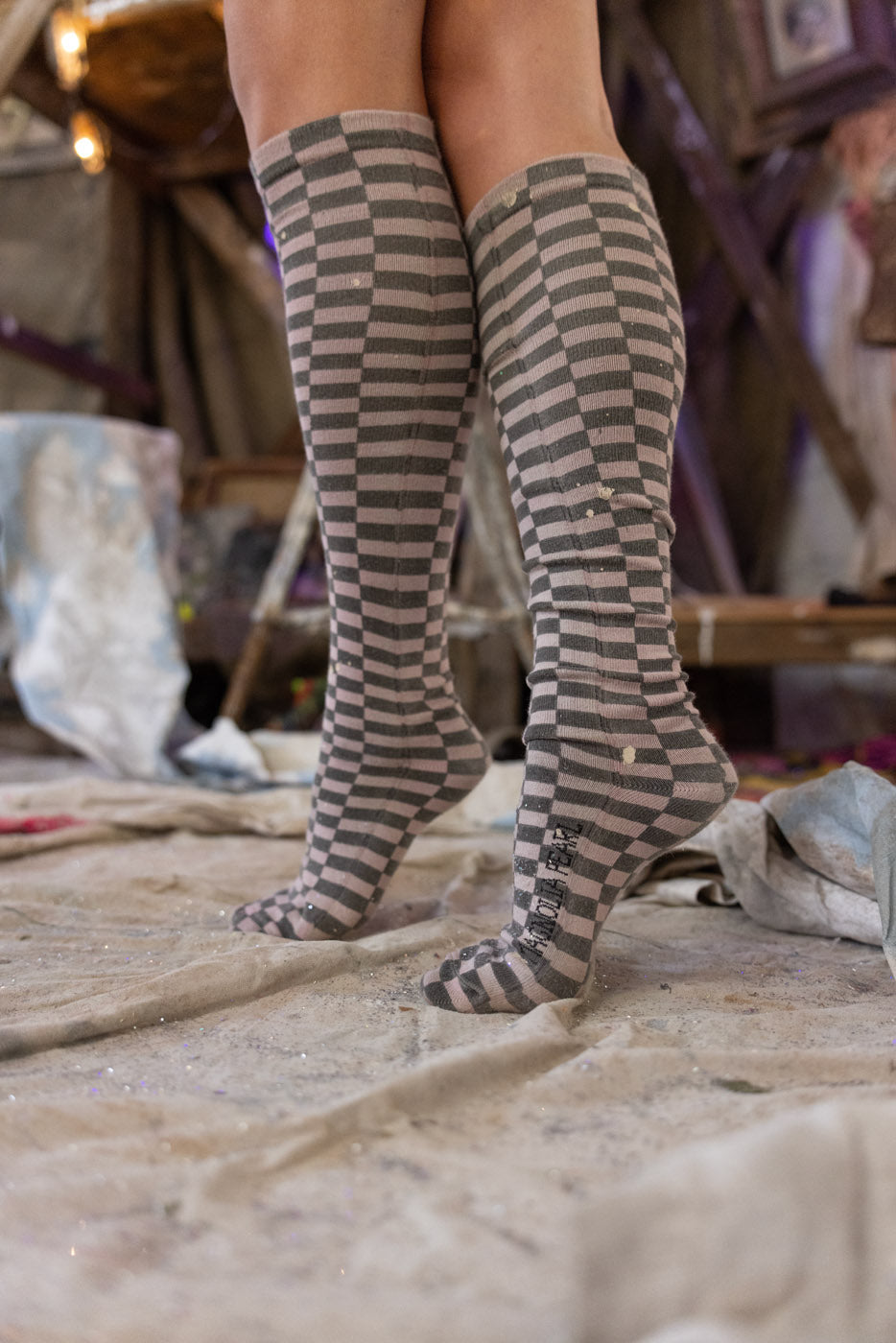 checkered knee-high socks worn by a person on a rustic background