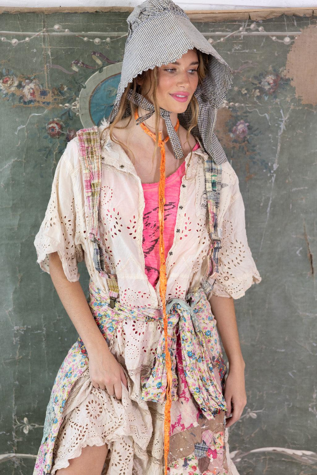 Woman in Magnolia Pearl artisan dress with lace, patchwork, floral scarf, and whimsical bonnet