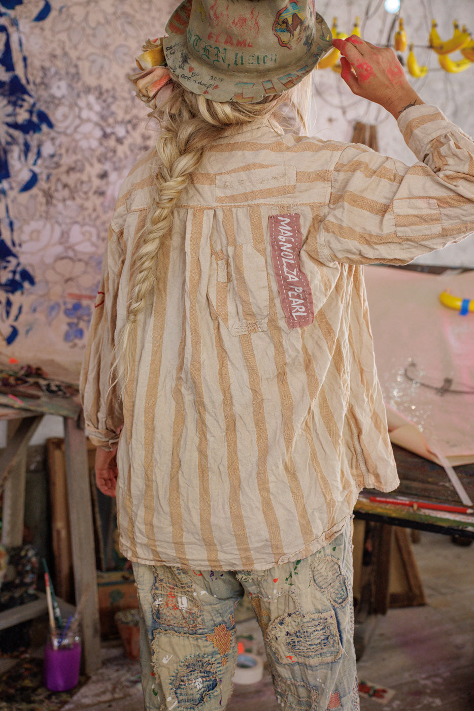 Magnolia Pearl artisan striped shirt and patched pants with whimsical vintage style, artist studio setting