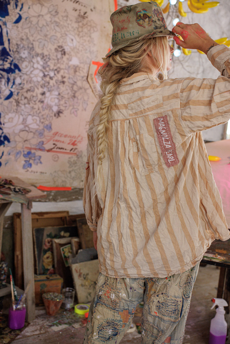 Magnolia Pearl artisan striped shirt with vintage patch, whimsical hand-painted pants, boho studio