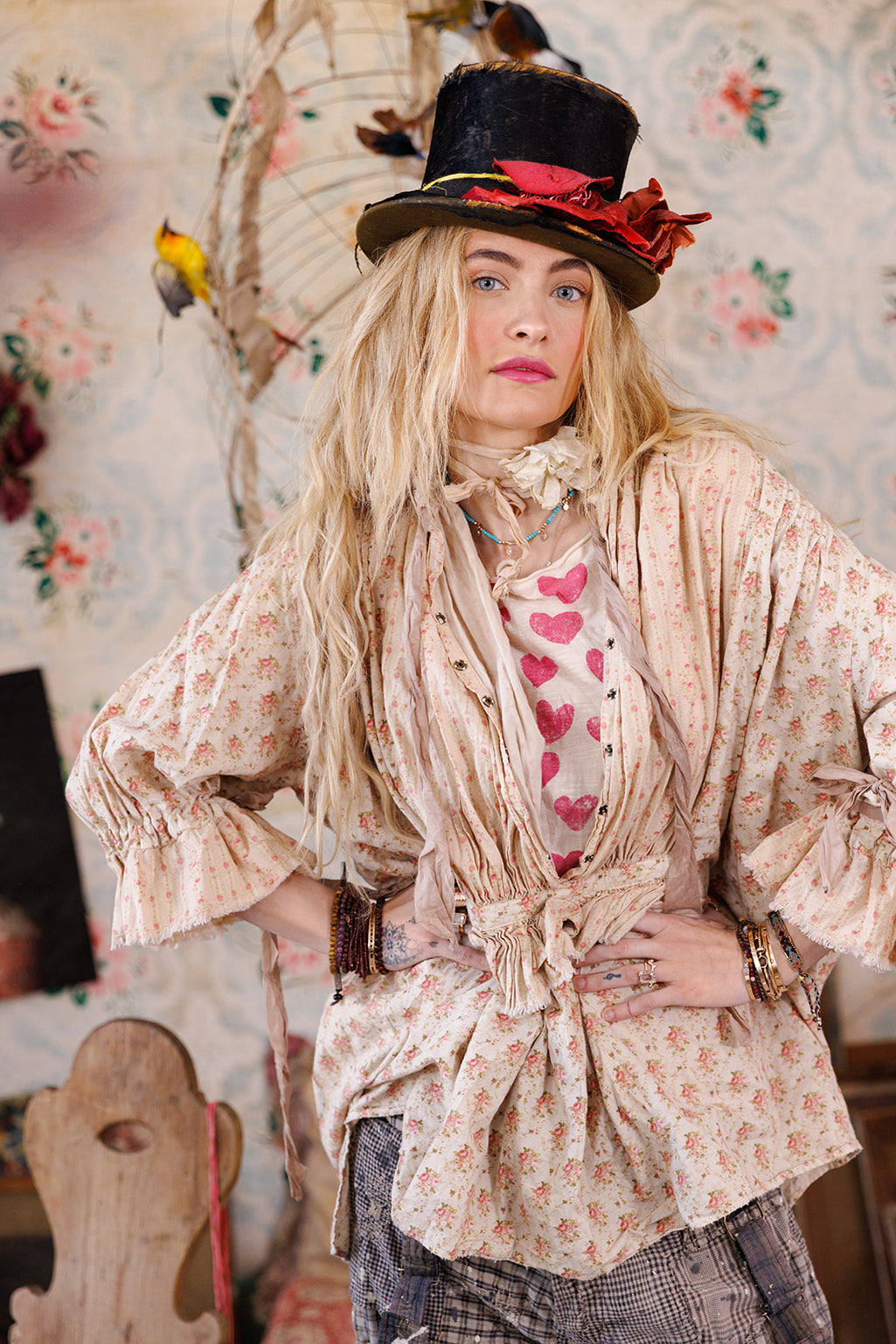 Woman in Magnolia Pearl vintage floral blouse, heart shirt, whimsical top hat, artisan clothing