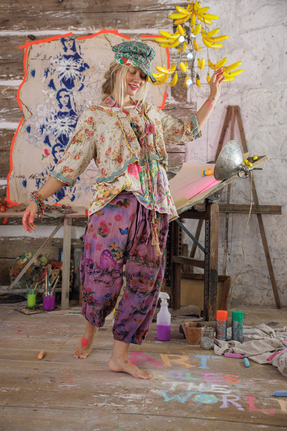 Woman in Magnolia Pearl vintage floral artisan clothing, whimsical studio, colorful art decor