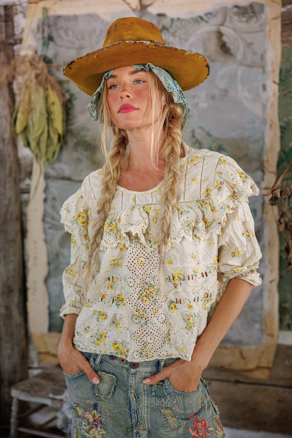 Woman in Magnolia Pearl vintage floral lace blouse and embroidered jeans, rustic setting, artisan whimsical style