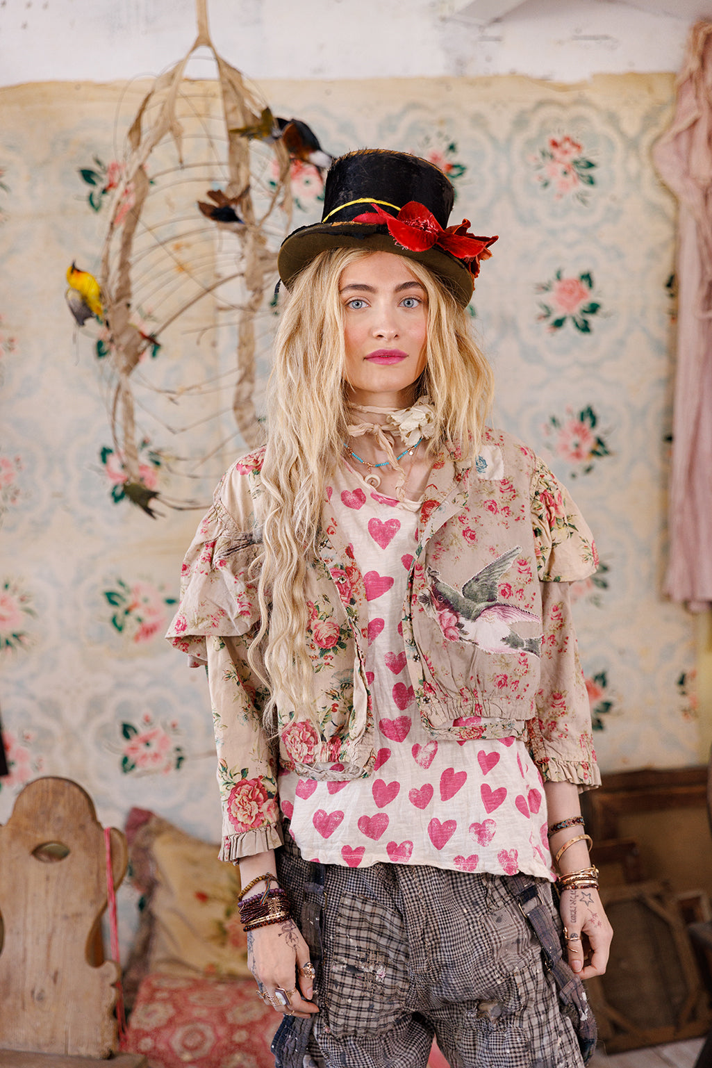 Woman in Magnolia Pearl floral jacket, heart shirt, and top hat, vintage whimsical artisan style