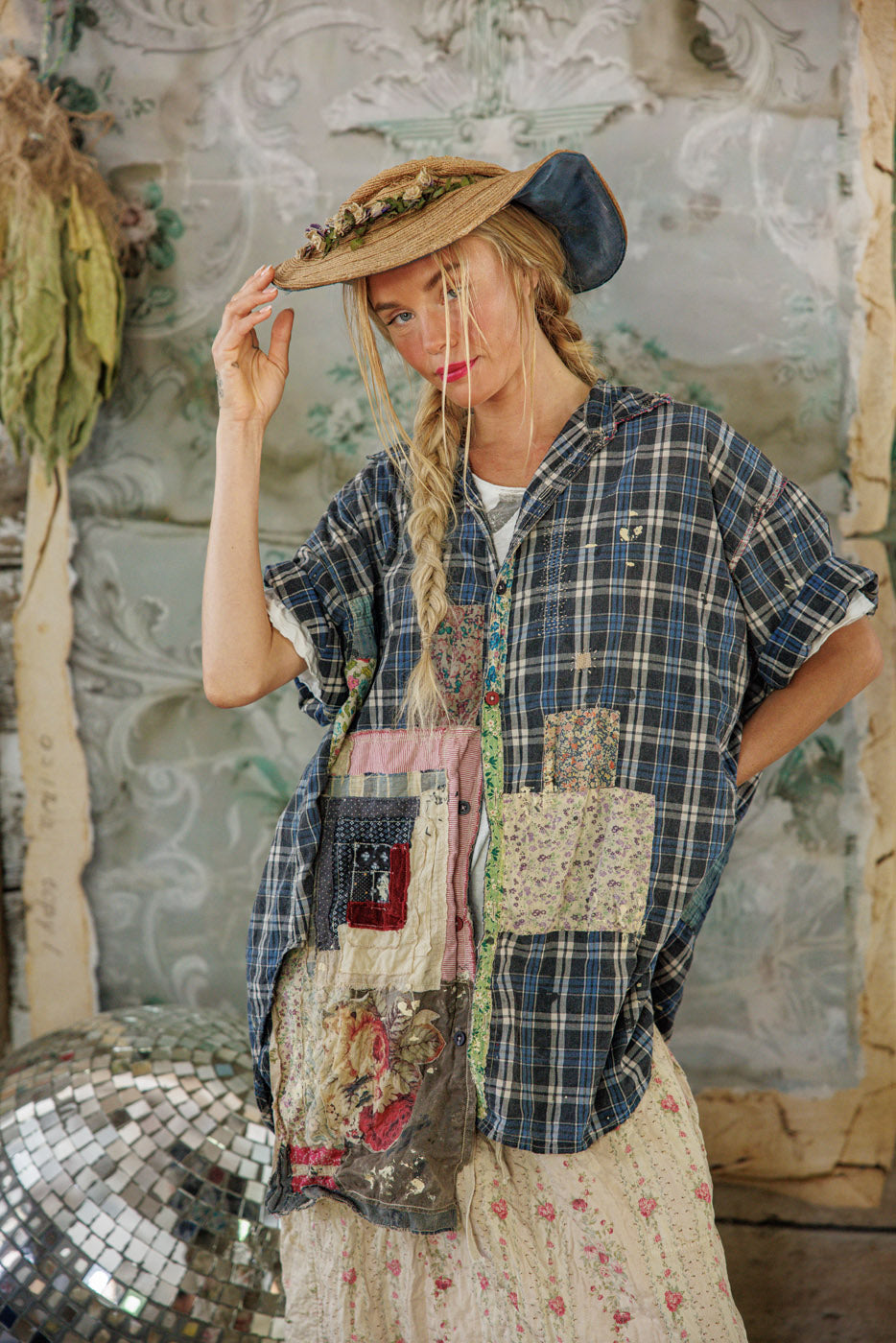 Woman in Magnolia Pearl artisan patchwork plaid shirt and vintage floral skirt, rustic setting