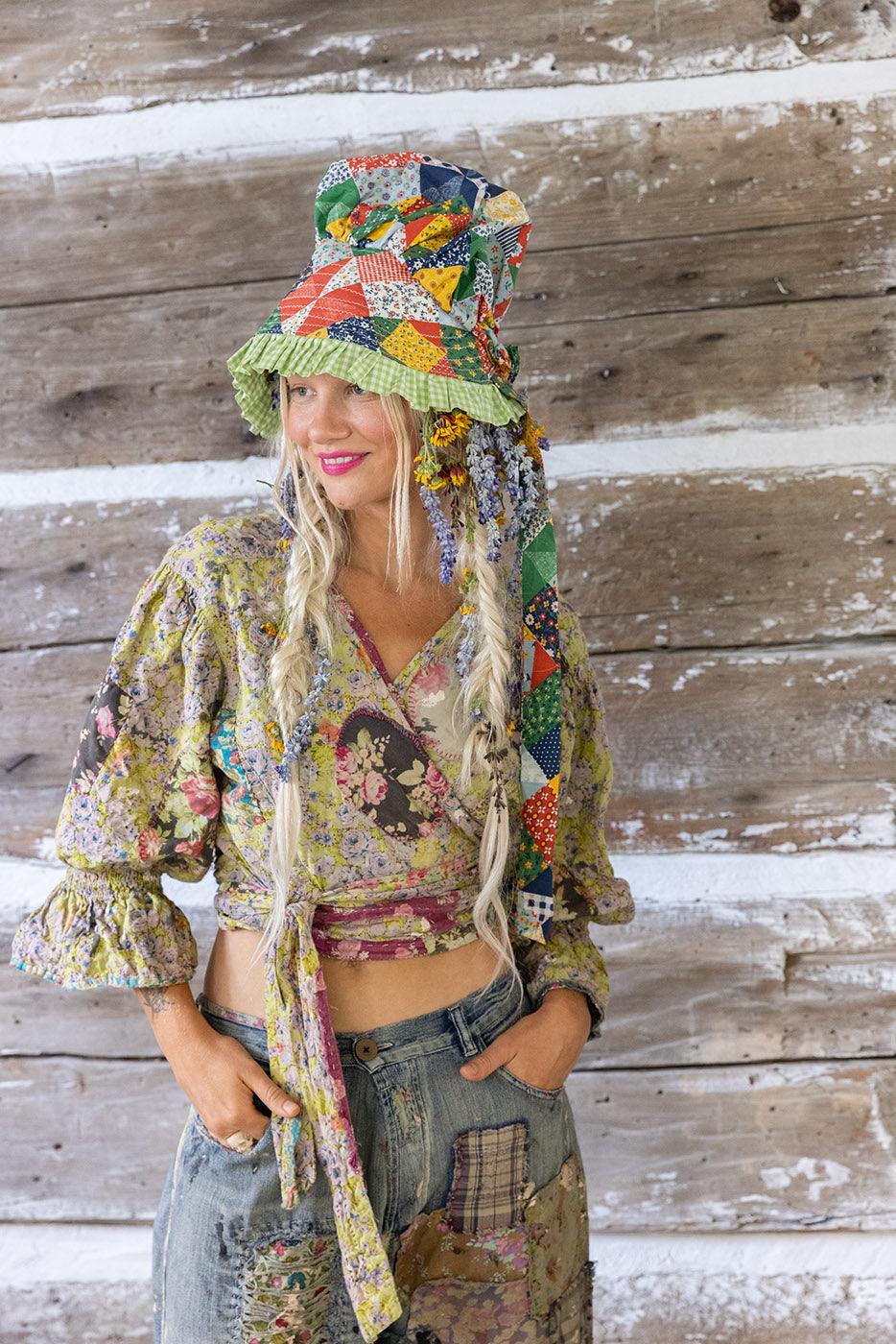Magnolia Pearl woman in vintage patchwork hat, floral wrap top, and distressed artisan jeans
