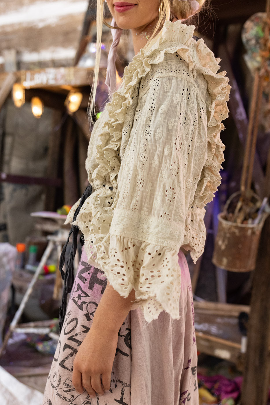 Person wearing a bohemian lace blouse with a blurred background