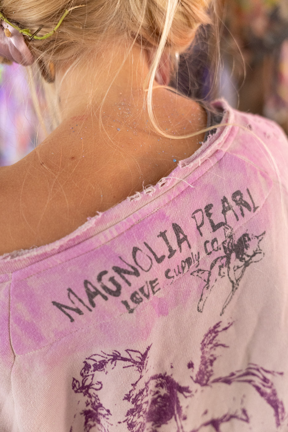 Person wearing a pink garment with 'Magnolia Pearl' branding