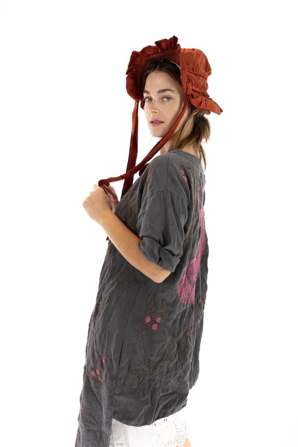 Magnolia Pearl artisan vintage dress with whimsical pink bird design, worn with lace trim and bonnet