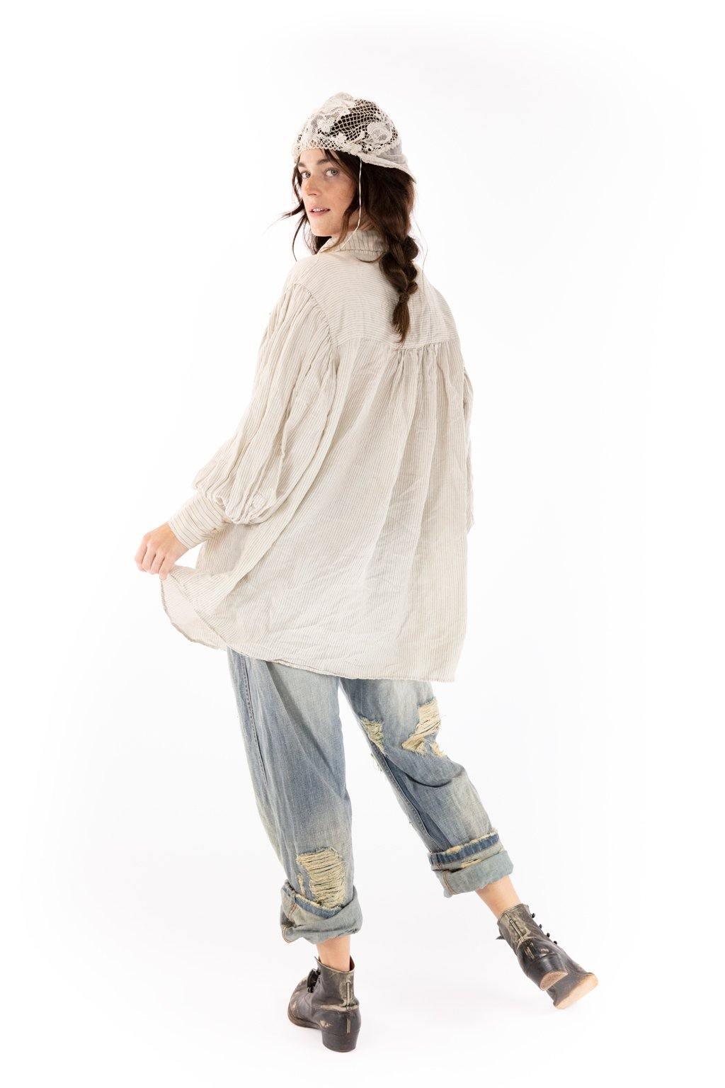 Woman wearing Magnolia Pearl artisan vintage-style blouse, distressed jeans, lace hat, and boots