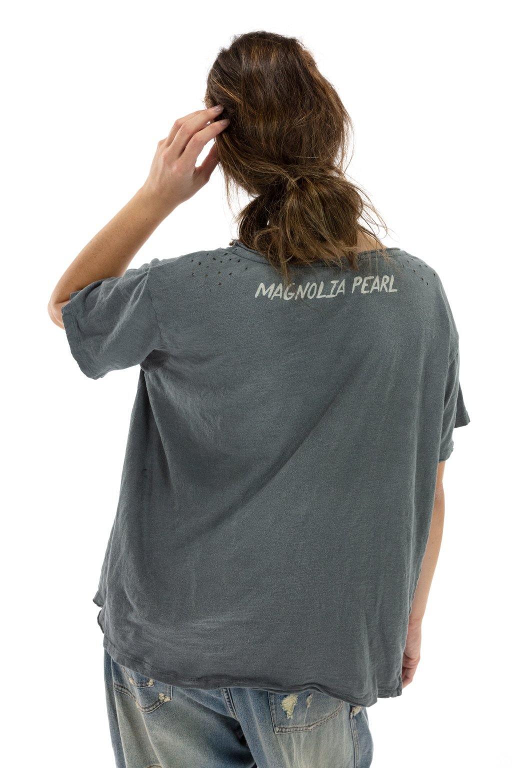Woman in Magnolia Pearl distressed grey artisan t-shirt and vintage jeans, back view