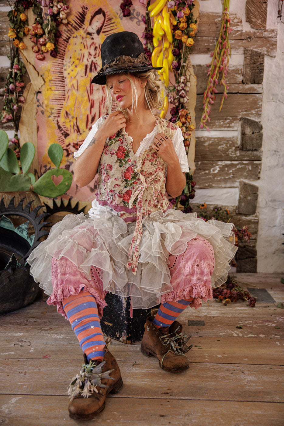 Woman in Magnolia Pearl artisan floral vest and ruffled skirt, whimsical vintage style setting
