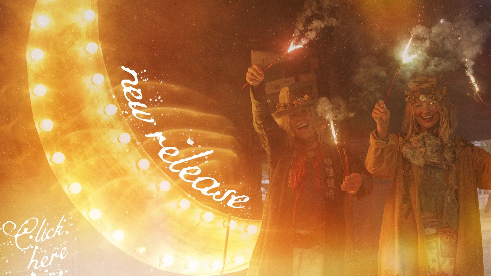 A festive scene with two people standing in front of a large glowing marquee light at night, holding sparklers or fireworks. The image has warm golden-orange lighting, smoke, and decorative text reading 'new release' and 'Click here'.