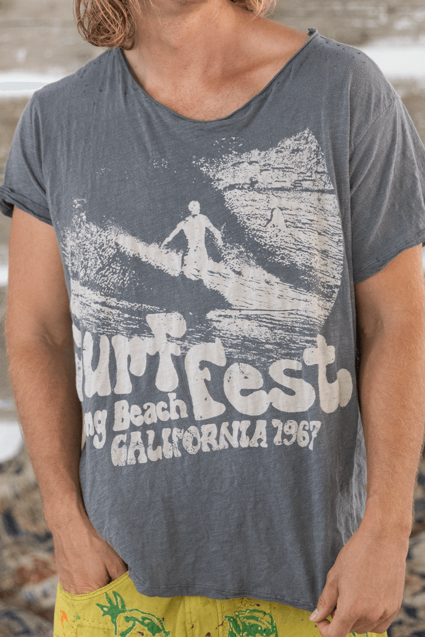 Man wearing vintage Surf Fest Long Beach California 1967 t-shirt on sandy beach