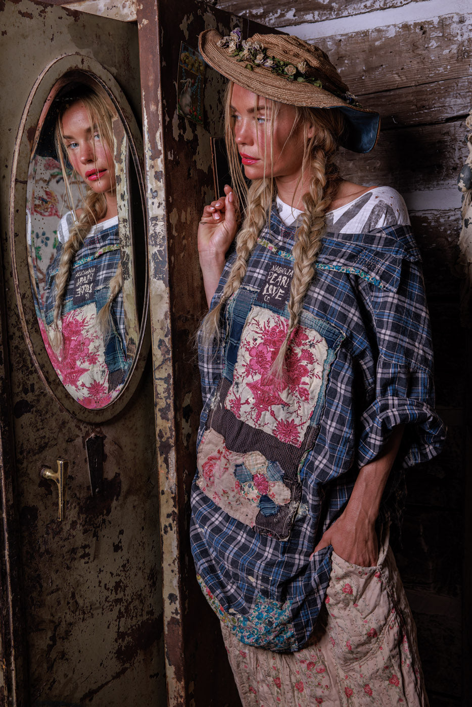 Woman in Magnolia Pearl artisan vintage patchwork top and floral straw hat, rustic setting