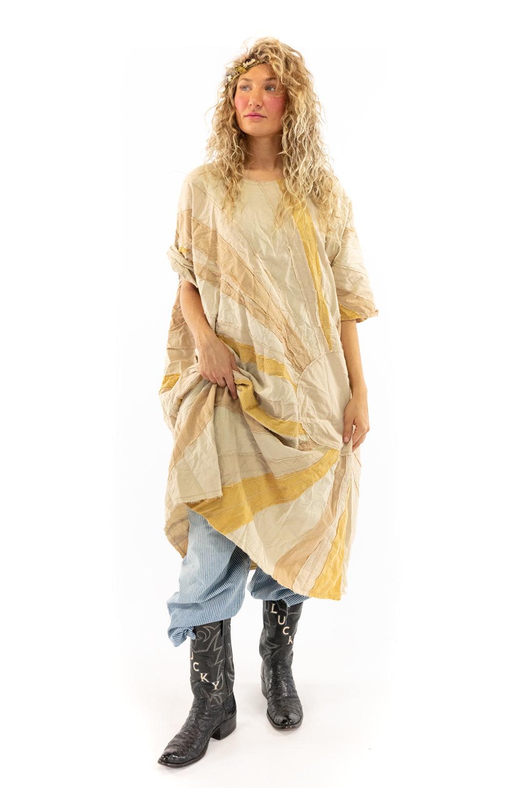 Woman in Magnolia Pearl artisan vintage-style dress with whimsical pattern, layered with jeans and unique boots